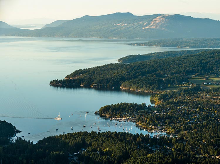 An aerial landscape view of Salt Spring Island by the Strait of Georgia as a ferry approaches the island in BC